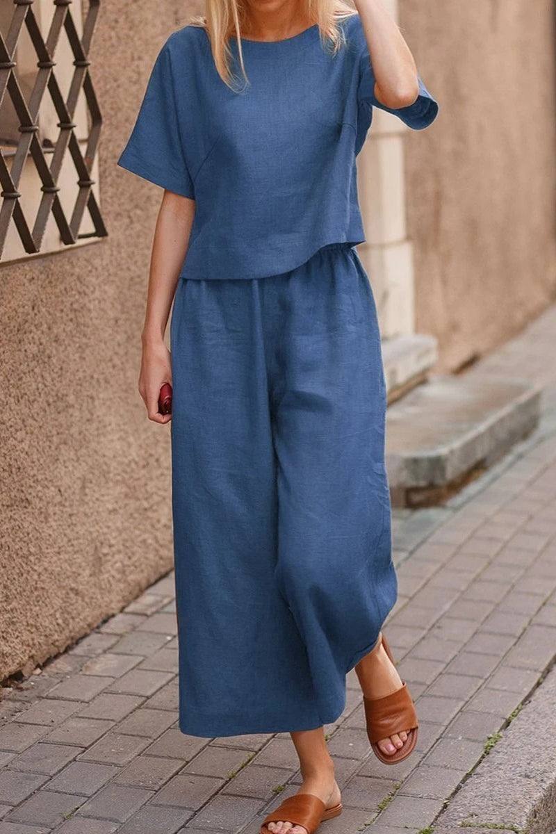 Woman wearing blue loose fit co-ord set with wide-leg pants and short sleeves walking outdoors