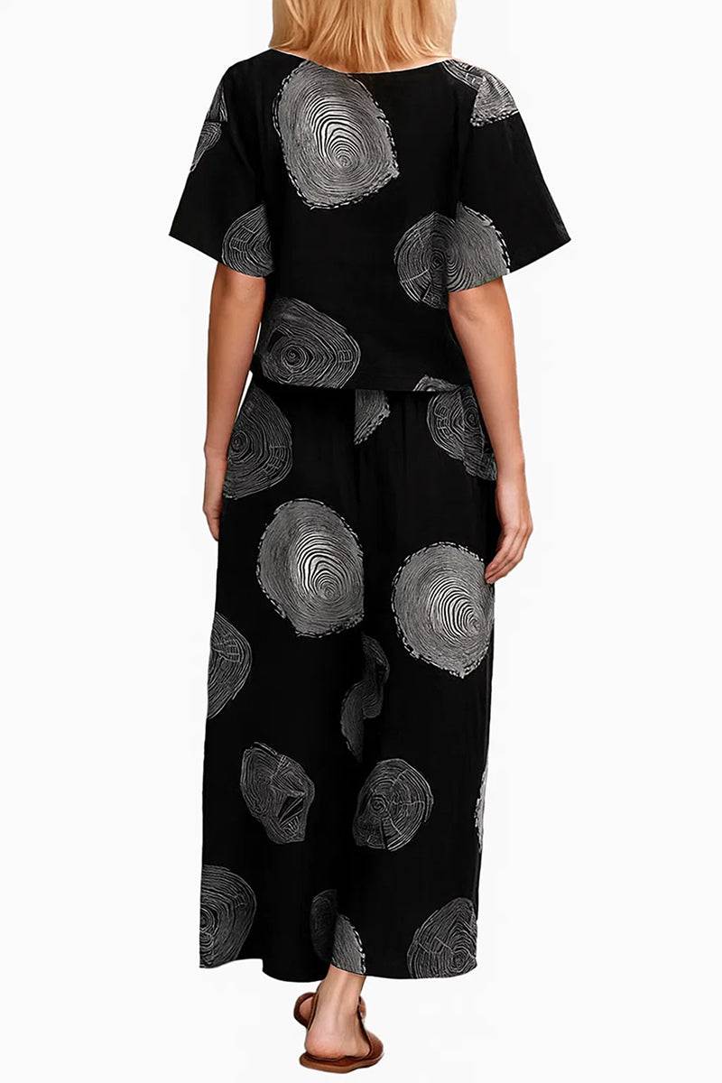 Back view of black loose fit co-ord set with large gray circular prints, featuring a relaxed short-sleeve top and wide-leg pants