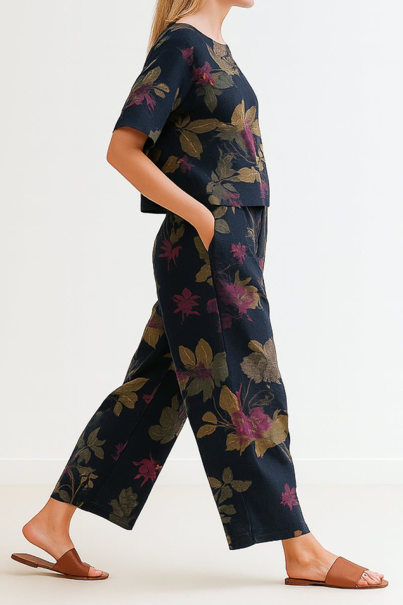 Woman wearing a floral loose fit co-ord set with wide-leg pants and short-sleeve top, paired with brown sandals