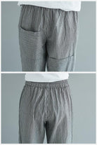 Close-up of high waist striped comfort pants with pockets and elastic waistband in gray and white stripes