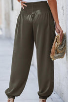 Boho Dreamer High-Waist elastic pants in olive green with smocked waistband and cuffed ankles, styled with a tassel handbag.