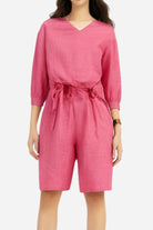 Pink two-piece set with loose V-neck shirt and high-waisted knee-length shorts in breathable cotton fabric