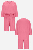 Pink two-piece set with loose long-sleeve shirt and high-waisted knee-length shorts in breathable cotton fabric