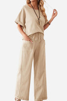 Woman wearing beige rolled cuff top and patch pocket pants set, casual relaxed fit outfit