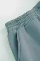 Close-up of grey cotton-blended two-piece tracksuit with elastic waistband and pocket detailing