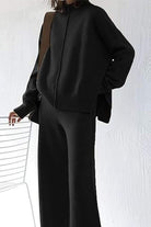 Black high neck sweater and wide leg pant set with relaxed fit and center seam detail