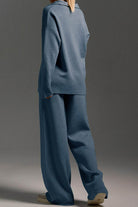 Back view of a model wearing a blue Plush & Preppy Camel Two-Piece Set with wide-leg pants and a loose long-sleeve top against a gray background