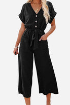 Black V-neck lace-up jumpsuit with pockets and tie waist, wide-leg design.