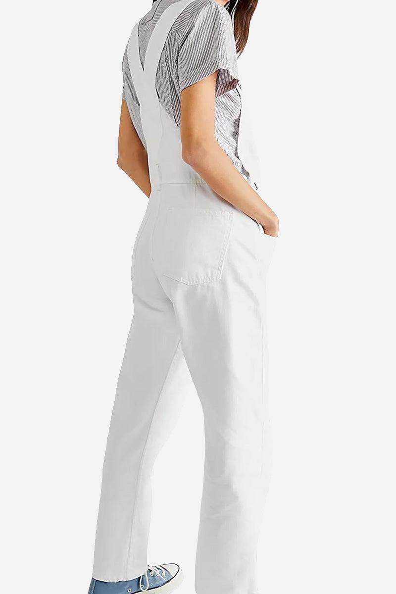 White denim-look tapered-leg adjustable bib overalls with pockets worn by woman viewed from back