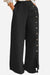Black wide leg pants with side button detail and high waist, made from breathable cotton blend.