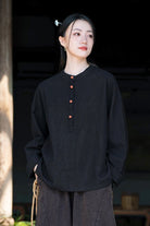 Woman wearing black ramie linen and cotton blouse with long sleeves and buttons