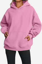 Pink oversized fleece-lined hoodie with front pocket and relaxed fit on model