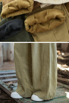 Folded sandwashed ramie linen pants in earth tones and close-up of wide-leg fit with white sneakers outdoors