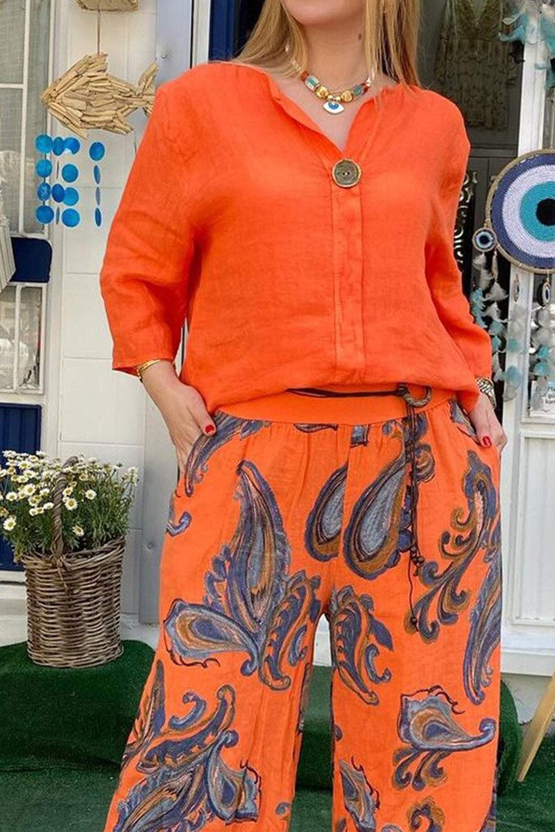 Woman wearing vibrant orange long sleeve top and paisley patterned pants from Vibrant Fusion Two-Piece Set