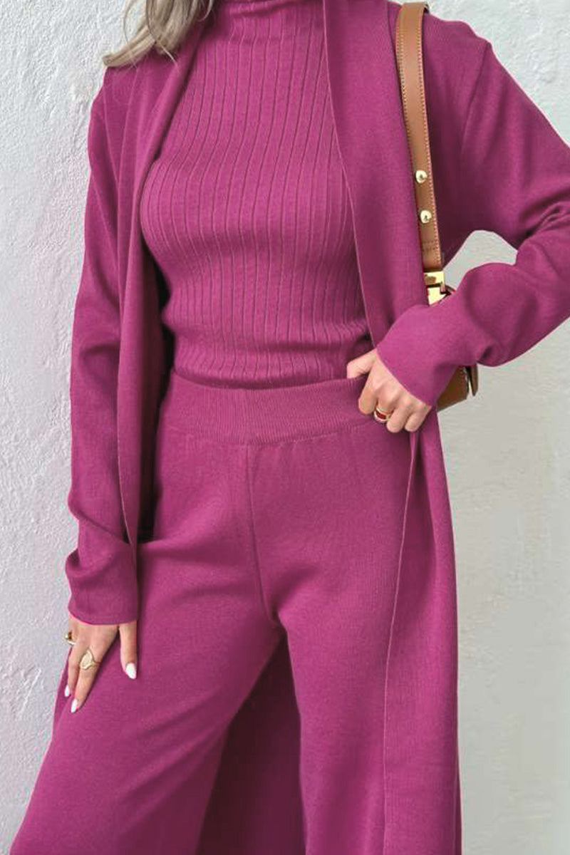 Woman wearing a magenta one-size three-piece collection with ribbed top, pants, and long cardigan