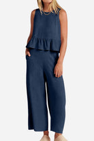 Woman wearing navy blue linen-like feel set with sleeveless ruffle top and wide-leg pants