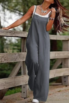 Woman wearing gray wide-leg cotton blend comfort jumpsuit outdoors by wooden fence