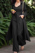 Woman wearing black relaxed fit shirt and trouser three-piece set with long shirt and wide-leg trousers outdoors