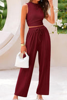Woman wearing burgundy Stroll & Hangout Ribbed Knit two-piece set with sleeveless top and wide-leg pants holding white bag outdoors