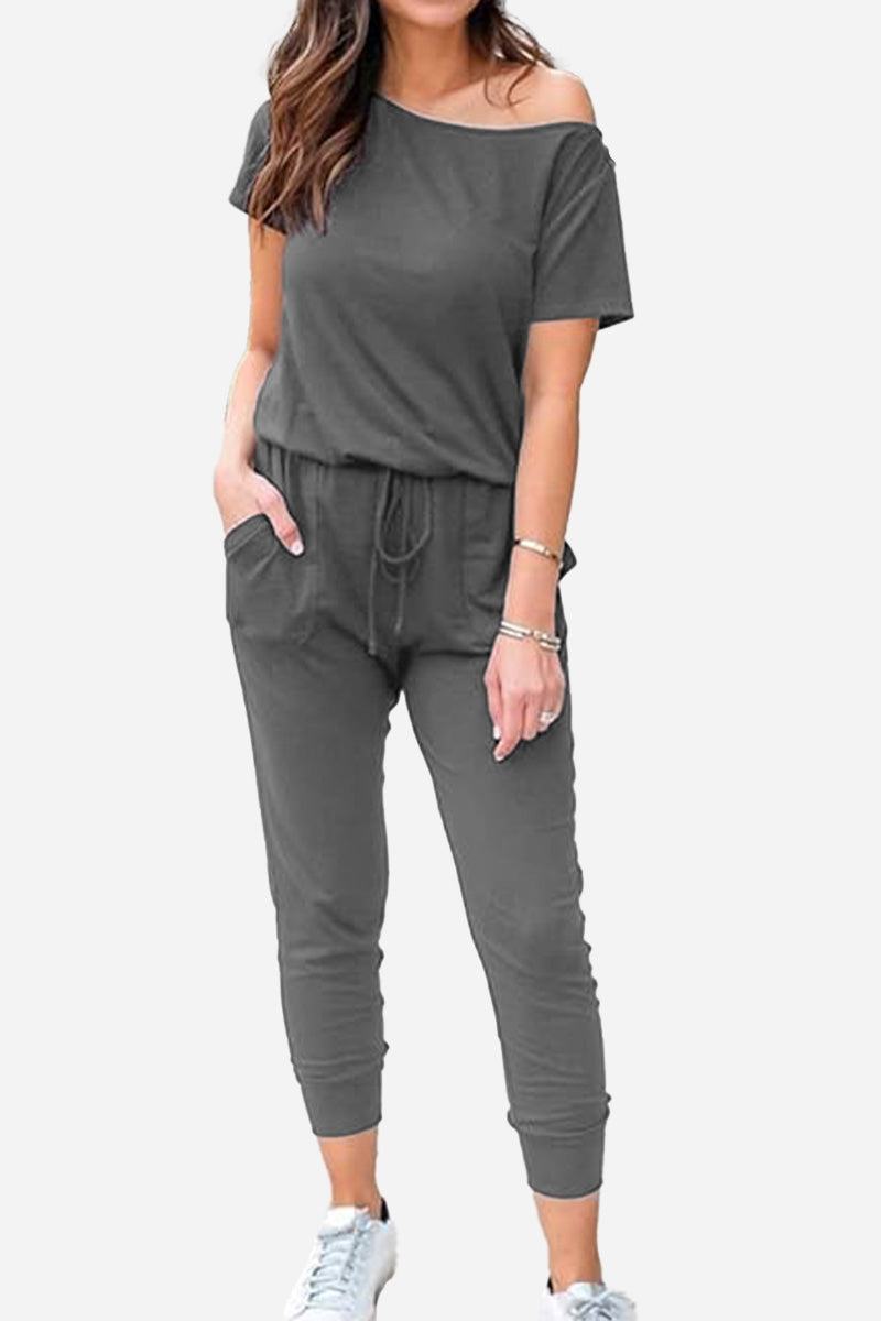 Woman wearing Moonlit Rome Off-Shoulder Jumpsuit in gray with pockets and tapered pants