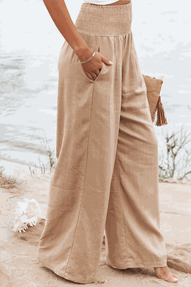 Woman wearing beige linen-cotton blend wide-leg pants from the Linen Breeze Set at the beach.