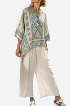 Woman wearing Santorini Sunset Striped two-piece set with patterned top and loose white pants