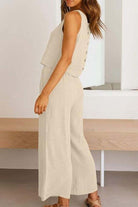 Woman wearing beige Villa Lounge Linen Set sleeveless crop top and wide-leg pants with elastic waistband and side pockets