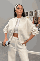 woman wearing The Voyager Zip Set in cream zip-front sweatshirt and wide-leg joggers, styled casually for travel or leisure