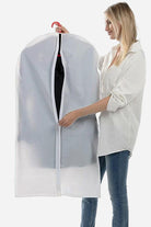 Woman holding waterproof dustproof clothing cover with zipper and hanger inside.
