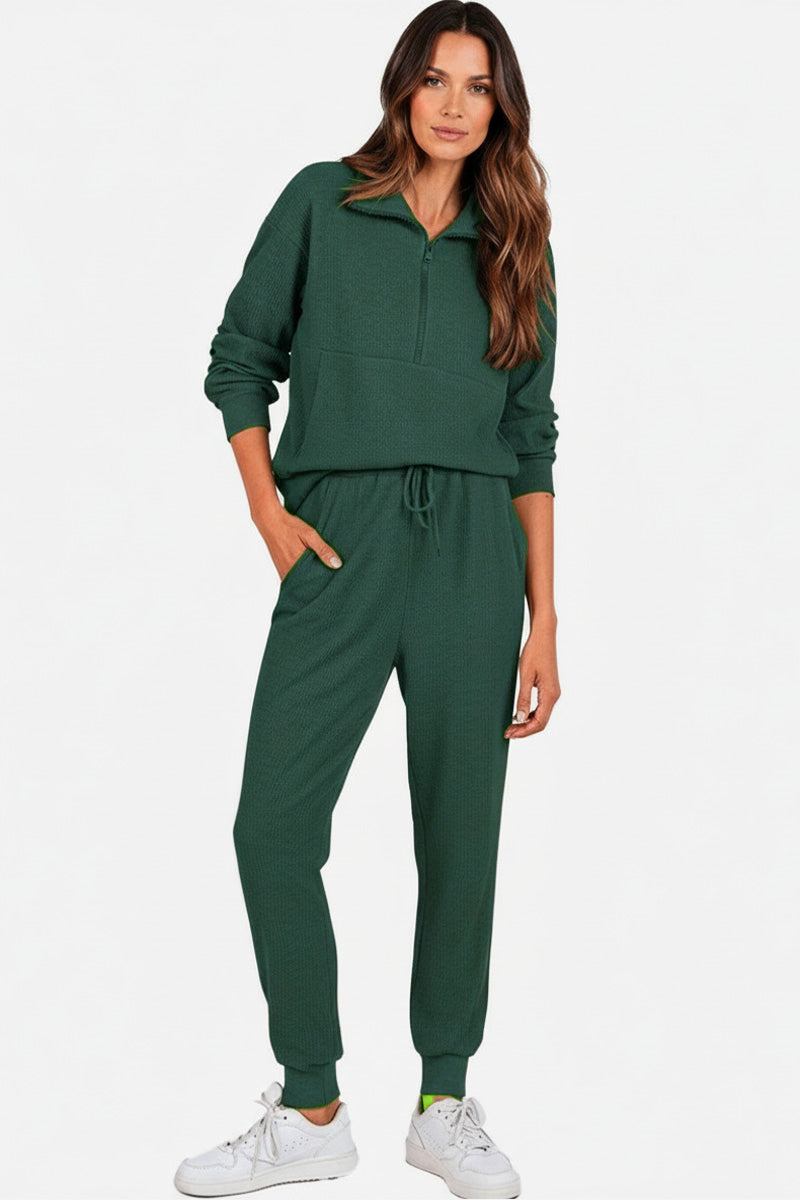 Woman wearing green unisex half-zip pullover and sweatpants set with casual fit and stand collar design