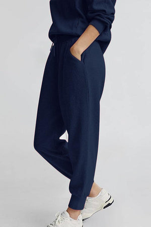 Unisex half-zip pullover and sweatpants set in navy blue with a casual, comfortable fit and breathable polyester blend fabric.