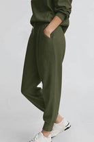 Unisex half-zip pullover and sweatpants set in olive green with a relaxed fit and casual style
