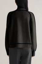 Back view of black Zero Itch Turtleneck Sweater with slimming contrast trim and relaxed fit.
