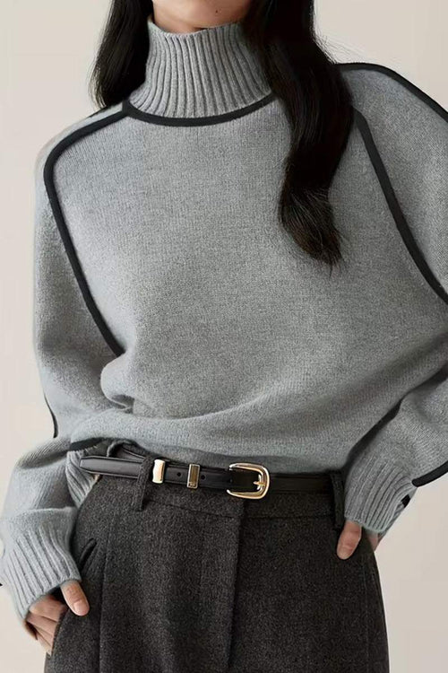 Woman wearing gray Zero Itch Turtleneck Sweater with black contrast trim and dark trousers