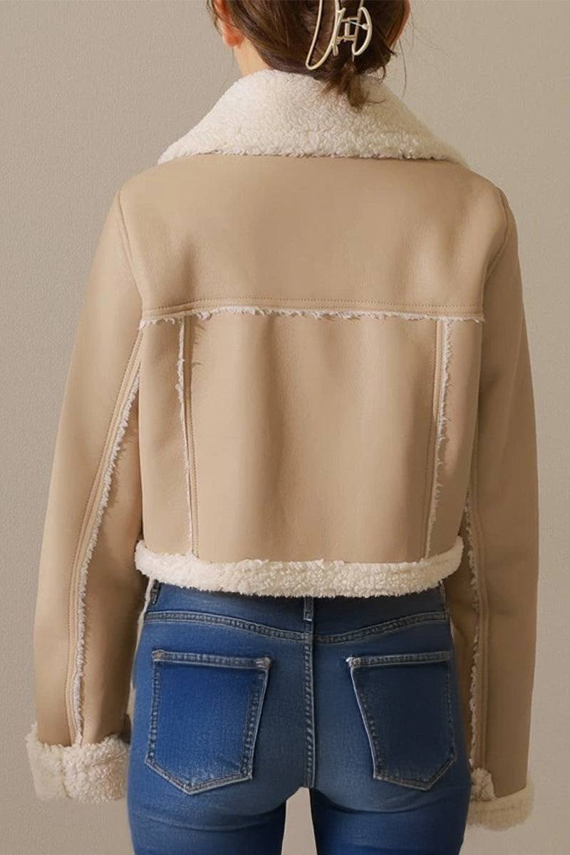 Back view of a beige cropped faux leather sherpa jacket with cream sherpa trim worn with blue jeans
