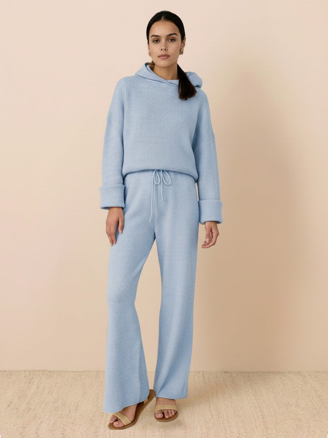 woman wearing light blue waffle-knit two-piece hoodie and pants set standing against beige background