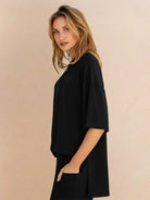 Woman wearing oversized long-line pullover and wide-leg pants loungewear set