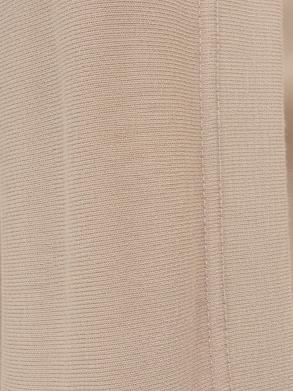 Woman wearing oversized long-line loungewear set with short-sleeve pullover and wide-leg pants.