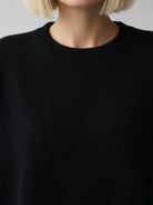 Oversized crew neck knit sweater with drop-shoulder sleeves and ribbed cuffs in neutral color