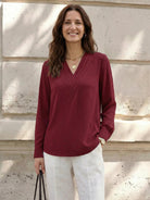 White pleated V-neck long-sleeve blouse with diagonal panel and button cuffs