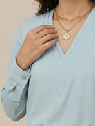 White pleated V-neck long-sleeve blouse with button cuffs and relaxed fit