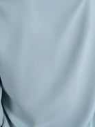 White pleated V-neck long-sleeve blouse with diagonal pleated detail and button cuffs