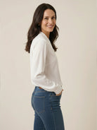 White pleated V-neck long-sleeve blouse with button cuffs and relaxed fit