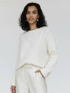 Oversized cable-knit crewneck sweater with dropped shoulders and thick plush fabric