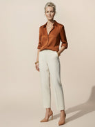 Silk-finish button front shirt with smooth fabric, relaxed fit, curved hem, and tone-on-tone buttons