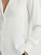 Silk-finish button front shirt with smooth fabric, traditional collar, and relaxed fit