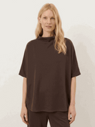 Woman wearing a cotton-blend capelet top with batwing sleeves and wide-leg pants lounge set