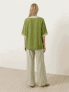 Woman wearing striped wide-leg co-ord set with oversized top and palazzo pants in multiple colors