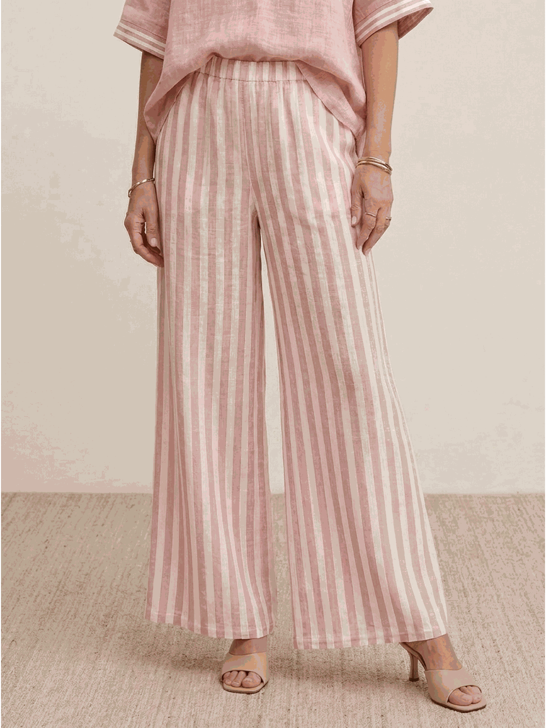 Woman wearing striped wide-leg co-ord set with oversized top and palazzo pants in multiple colors