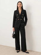 Woman wearing gold button double-breasted blazer with wide-leg trousers co-ord set